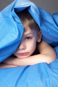 sleepy boy in blue bedclothes